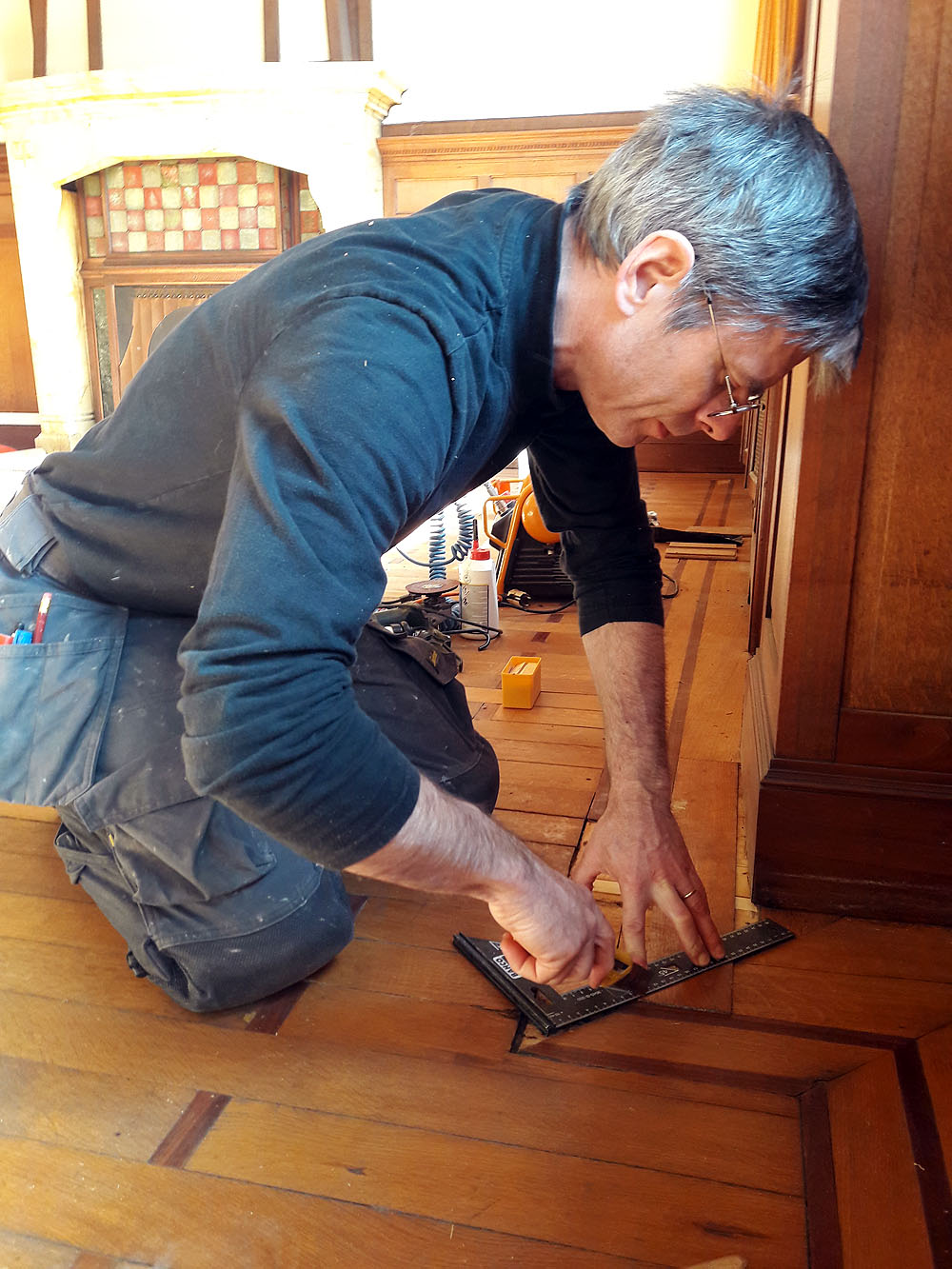 Rénovation du parquet de l'Alba, Charleroi, photo où je re-travaille l'angle de l'onglet afin de l'adapter à la greffe (frise reconstituer avec du chêne ancien)